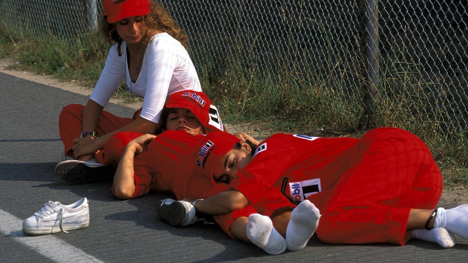 
                <strong>GP Deutschland 1994</strong><br>
                Ein Jahr später. Wieder Hockenheim. Ach ja, da war ja noch was. Damals gab es auch noch Grid Girls, meistens auch ausgeschlafenere als diese hier.
              