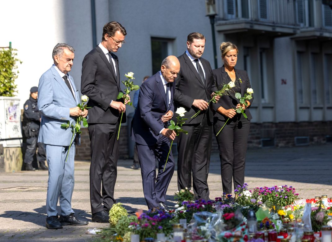 Herbert Reul (CDU, von links nach rechts), Innenminister von Nordrhein-Westfalen, Hendrik Wüst (CDU), Ministerpräsident von Nordrhein-Westfalen, Bundeskanzler Olaf Scholz (SPD), Tim Kurzbach (SPD), Bürgermeister von Solingen, und Mona Neubaur (Grüne), stellvertretende Ministerpräsidentin von Nordrhein-Westfalen, legen Blumen an einer Kirche in der Nähe des Tatorts ab.