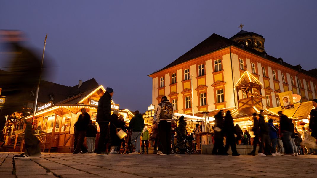 Menschen tummeln sich im Bayreuther Winterdorf. 