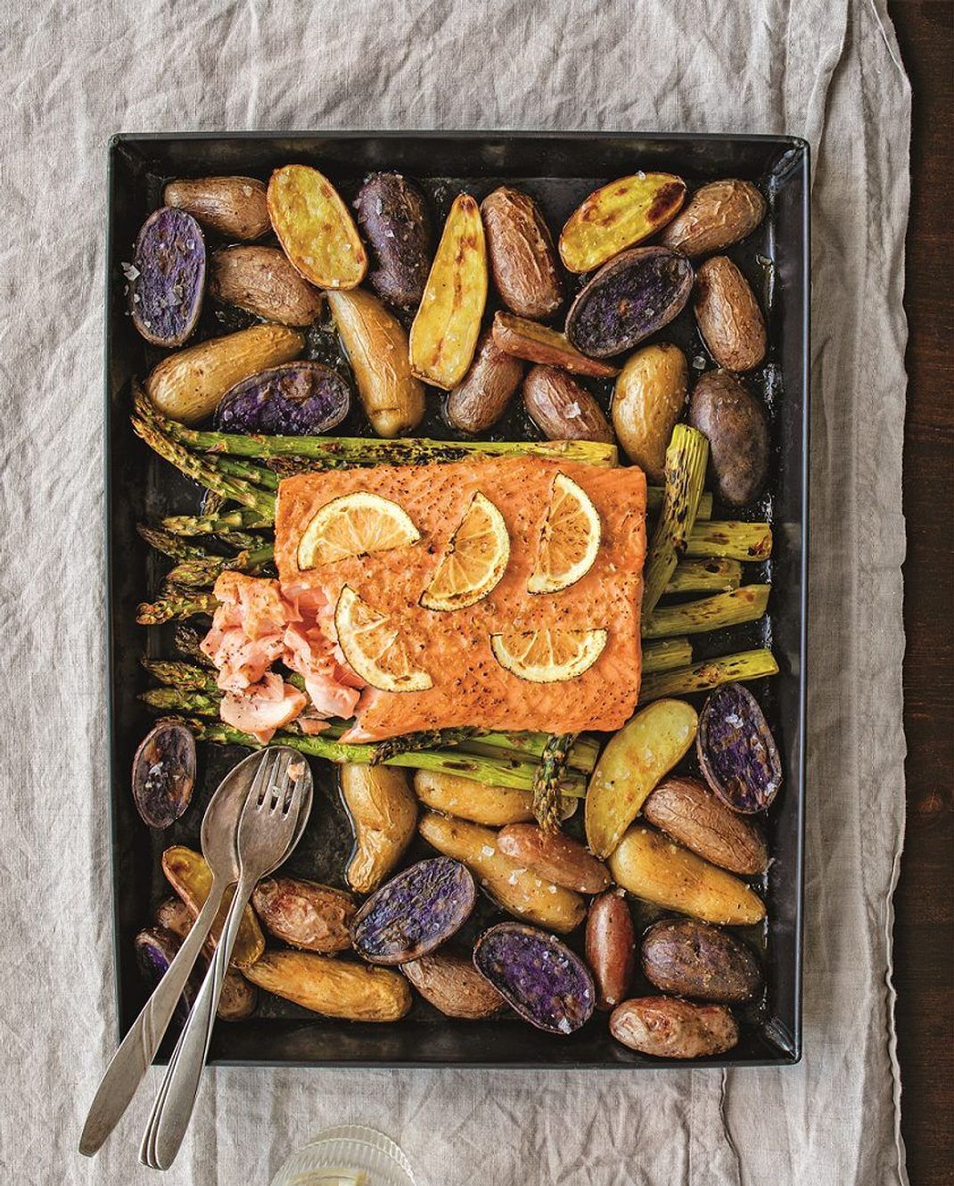 Ein Blech - ein Gericht: beim Kochtrend Sheet-Pan-Dinner wird alles auf einem Backblech gegart, wie hier ein Lachsfilet mit bunten Kartoffeln und Spargel.