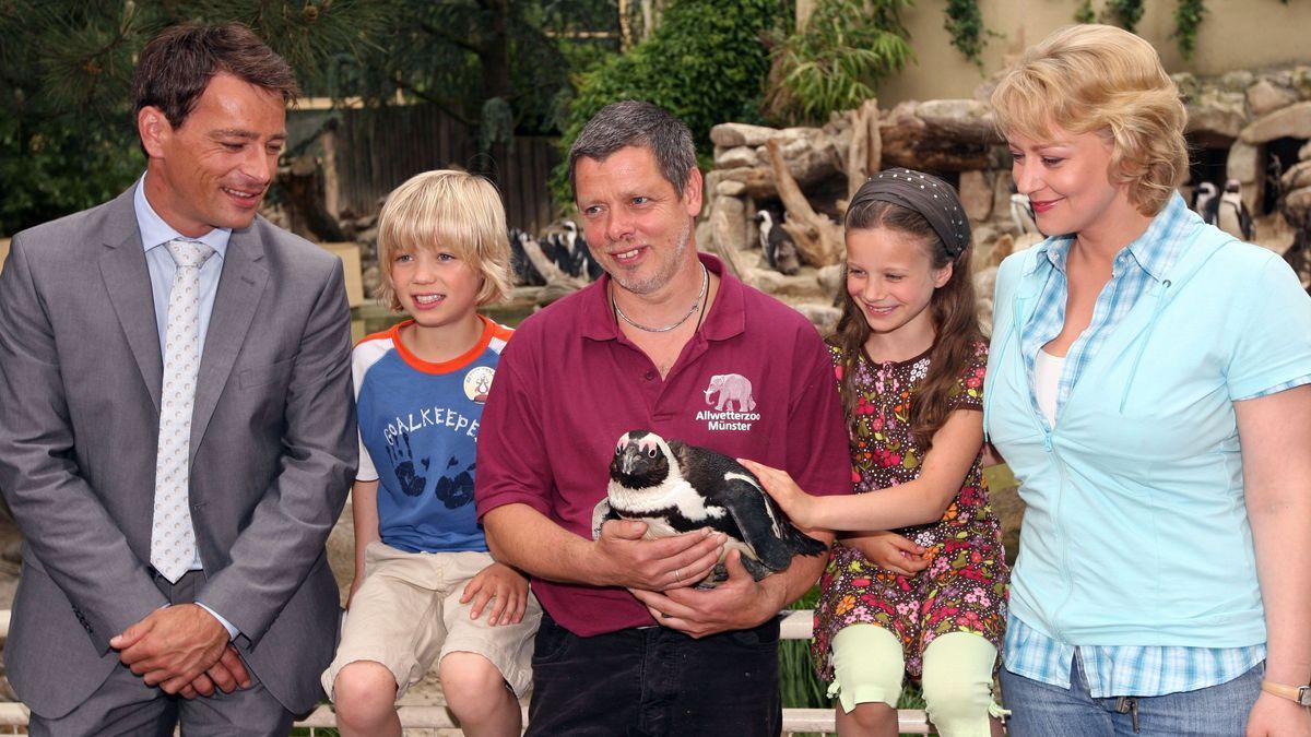 Schauspieler Jan Sosniok (v. l. n. r.), Tom Hoßbach, Pinguin-Revierleiter Peter Vollbracht, Julia Scherlitz und Floriane Daniel im Drehset am Pinguinbecken des Allwetterzoos Münster.