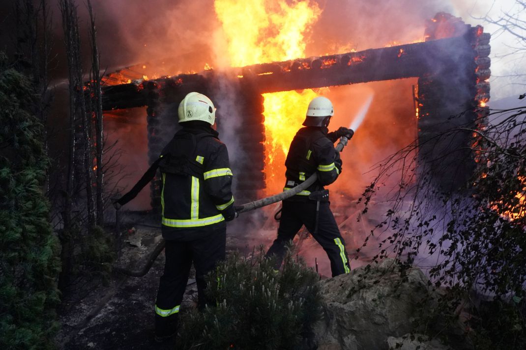 Ukraine, Charkiw: Feuerwehrleute löschen ein Feuer, nachdem ein Haus am 4. Mai von russischem Beschuss getroffen wurde. 