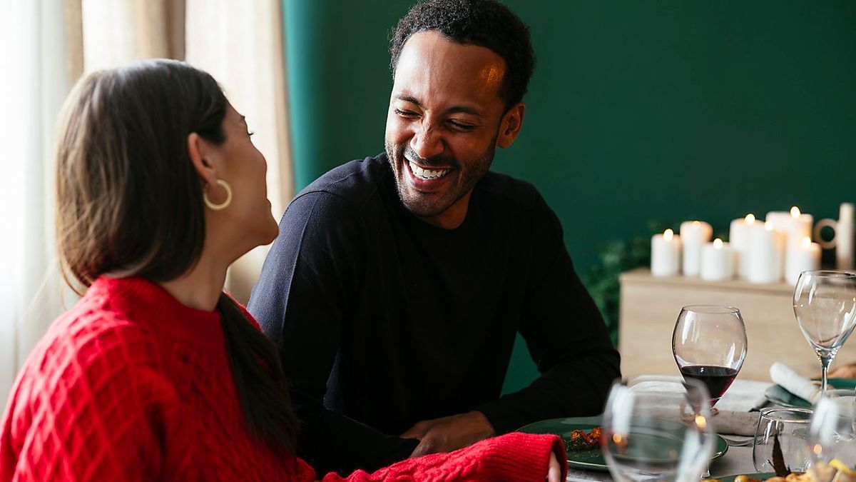 Happy heterosexual couple enjoys dinner party at home