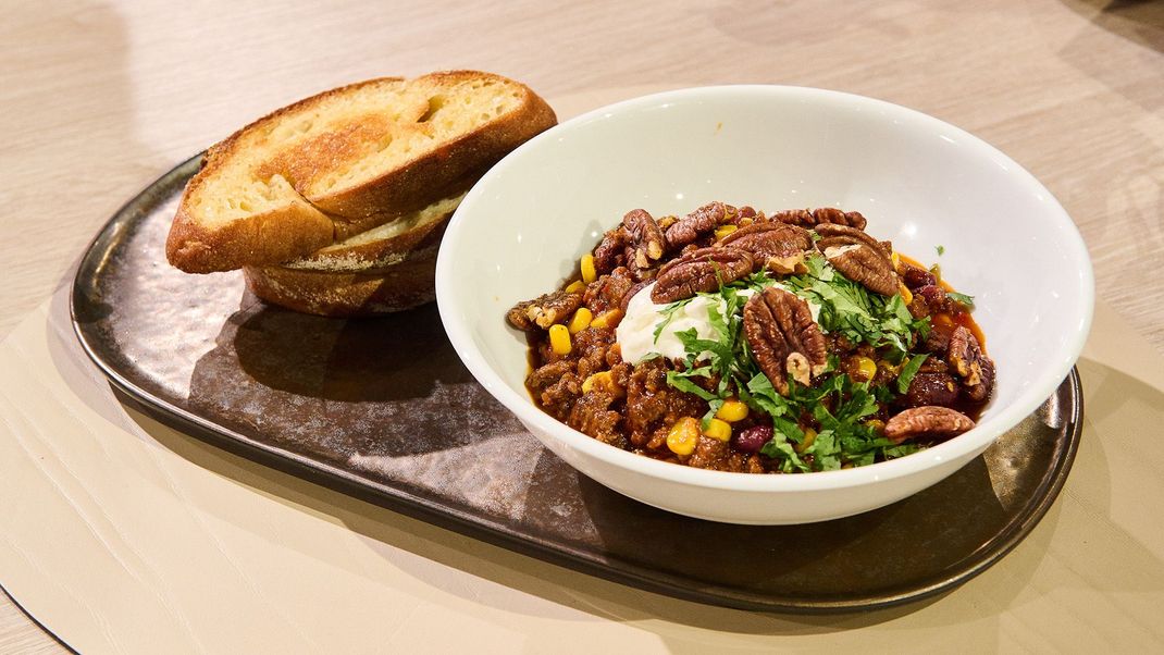 Chili con Carne mit feurigen Harissa-Pekannüssen und geröstetem Brot.