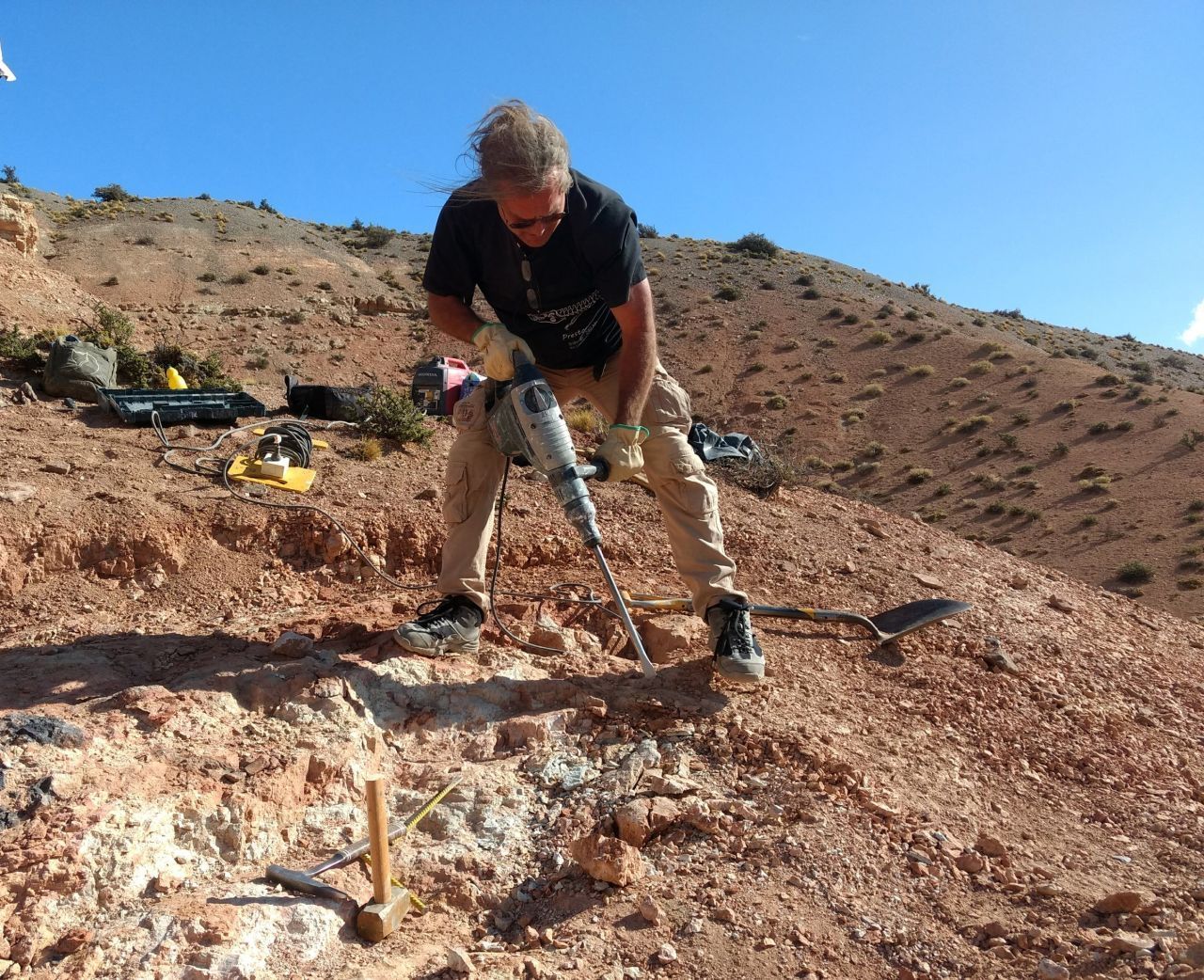 Paläontologe Oliver Rauhut bedient den Presslufthammer, um Steine mit Dinoknochen freizulegen.