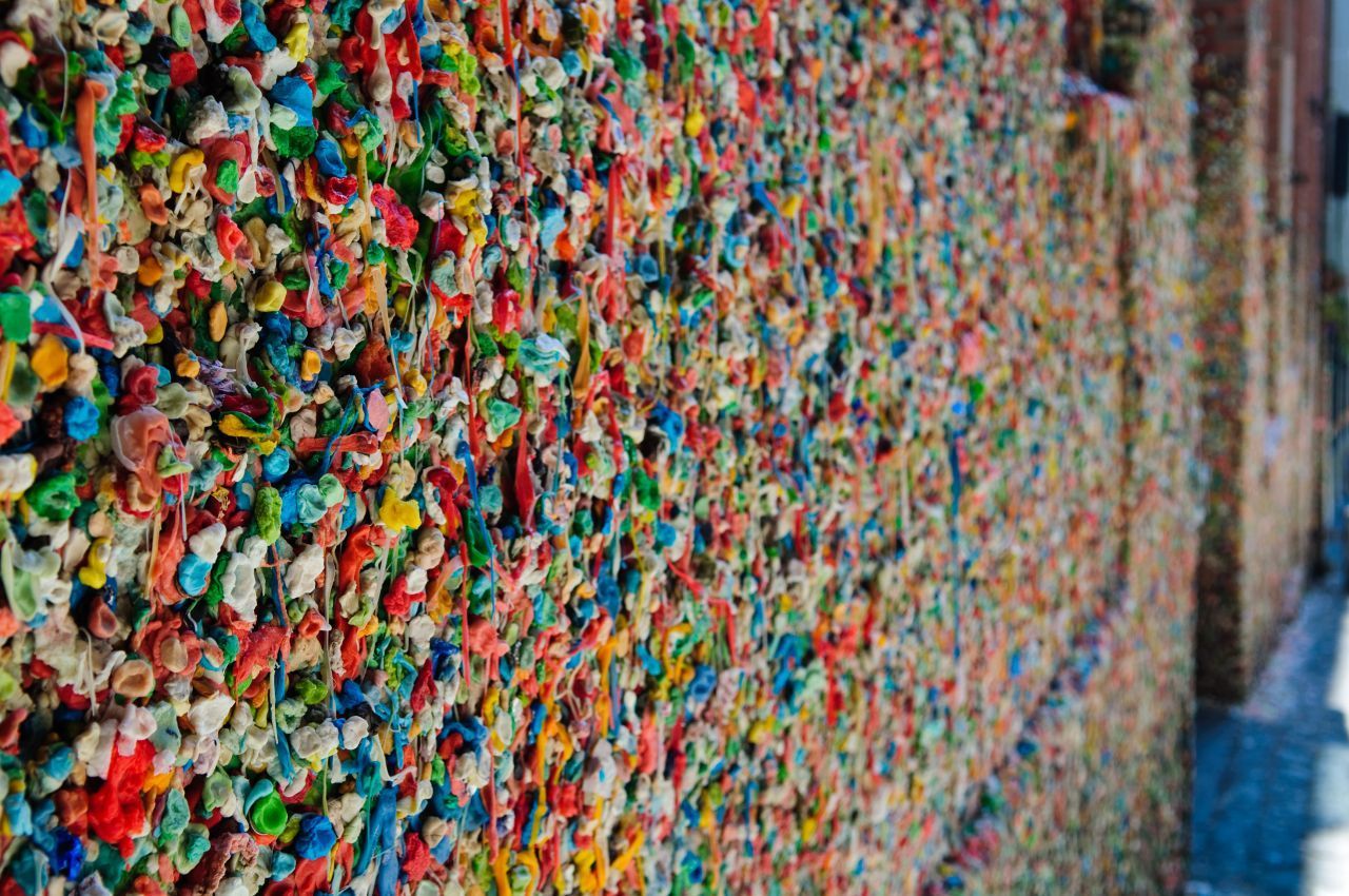 Die Gum Wall entstand Anfang der 1990er nahe eines Theaters in Seattle. Damals begannen Besucher beim Anstehen am Kartenschalter damit, ihre benutzten Kaugummis an die Wand zu kleben. Die erste Reinigung fand 2015 statt. Sie dauerte 130 Stunden, es wurden über 1.000 Kilo der zähen Masse entfernt.