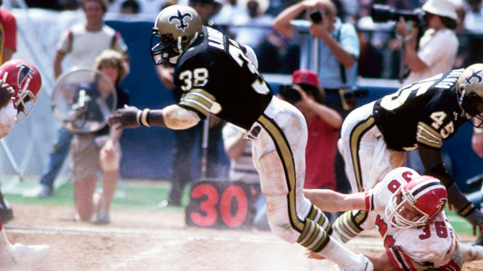 
                <strong>New Orleans Saints: George Rogers</strong><br>
                &#x2022; Rushing Yards: 1.674<br>&#x2022; Saison: 1981<br>Was für eine tragische Karriere. 1980 wurde er mit der Heisman Trophy ausgezeichnet, 1981 als Nummer-1-Pick im Draft ausgewählt. In seinem ersten Jahr wurde er schließlich als Rookie of the Year ausgezeichnet und konnte direkt den Franchise-Rekord der Saints aufstellen, der bis heute Bestand hat. Weil er sich 1982 wegen Kokainsucht in eine Entzugsklinik begeben musste, endete seine vielversprechende Karriere früh.
              