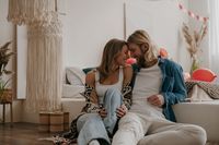Young romantic couple embracing face to face while celebrating Valentines day at decorated cozy home