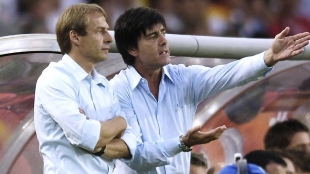 
                <strong>Sommermärchen und Co.</strong><br>
                Mit Jürgen Klinsmann ändert sich alles. Oder zumindest einiges. Er krempelt den DFB um und feiert mit seinem Co-Trainer Joachim Löw das unvergessene Sommermärchen 2006 und WM-Platz drei. Viel wichtiger: Bei jedem großen Turnier danach erreicht die Mannschaft mindestens das Halbfinale und wird 2014 Weltmeister. Alles unter Löw, denn die Karrieren der beiden Trainer entwickeln sich unterschiedlich. Klinsmann scheitert erst mit seinen Buddhas bei den Bayern, nach Jahren der Aufbauarbeit auch als US-Nationalcoach. Ist jetzt nur noch Beobachter, während Löw in seine dritte WM-Endrunde als Bundestrainer geht.
              