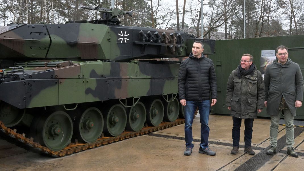 Wladimir Klitschko, Boris Pistorius und Oleksii Makeiev posieren vor einem Leopard 2 A6-Panzer auf einem Übungsgelände in Münster.