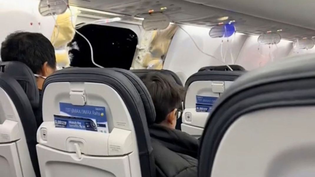 Passagiere in der Nähe des klaffenden Lochs an einer Boeing 737-9 Max.