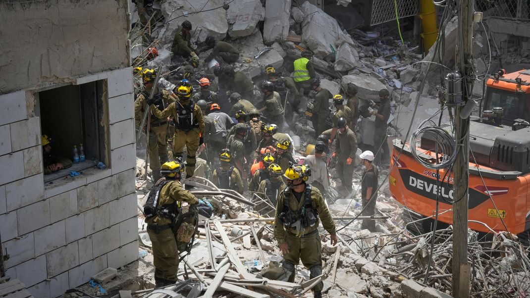 Israelische Soldaten suchen nach Überlebenden in den Trümmern von Wohnhäusern.