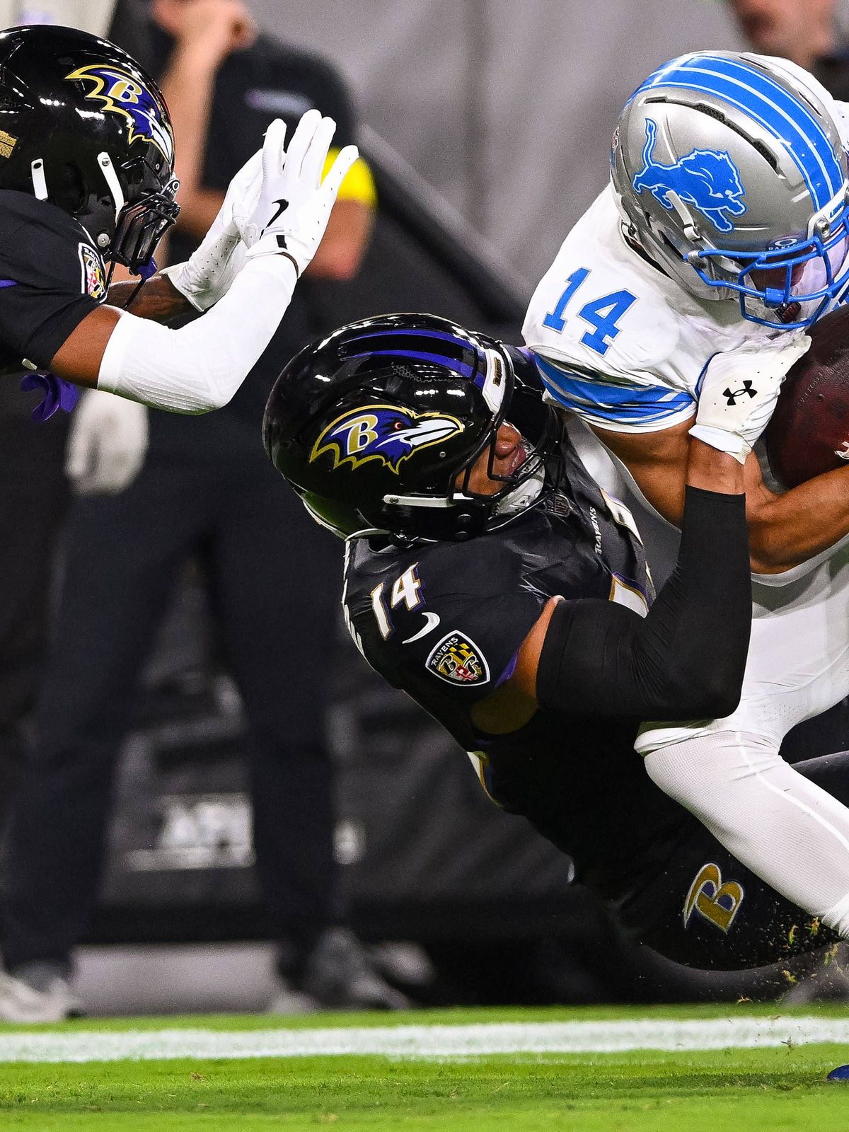 Detroit Lions wide receiver Amon-Ra St. Brown (14) makes a first down catch against Baltimore Ravens safety Kyle Hamilton (L) and cornerback Nate Wiggins (2) during the first quarter at M&T Bank St...