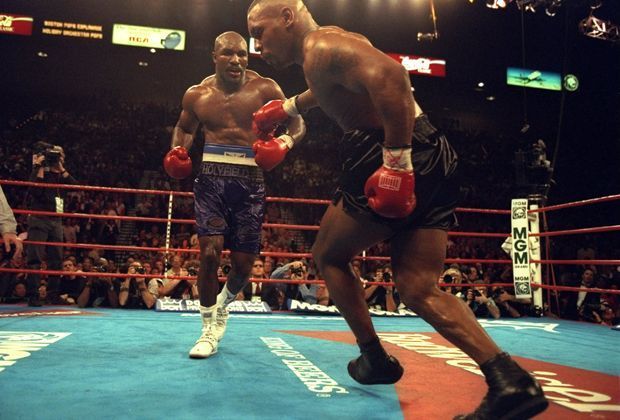 
                <strong>Evander Holyfield vs. Mike Tyson</strong><br>
                9. November 1996: Mike Tyson strauchelt beim Kampf gegen Evander Holyfield im MGM Grand Garden in Las Vegas, Nevada. Tyson verliert seinen Weltmeistertitel durch einen technischen K.o. in der elften Runde.
              