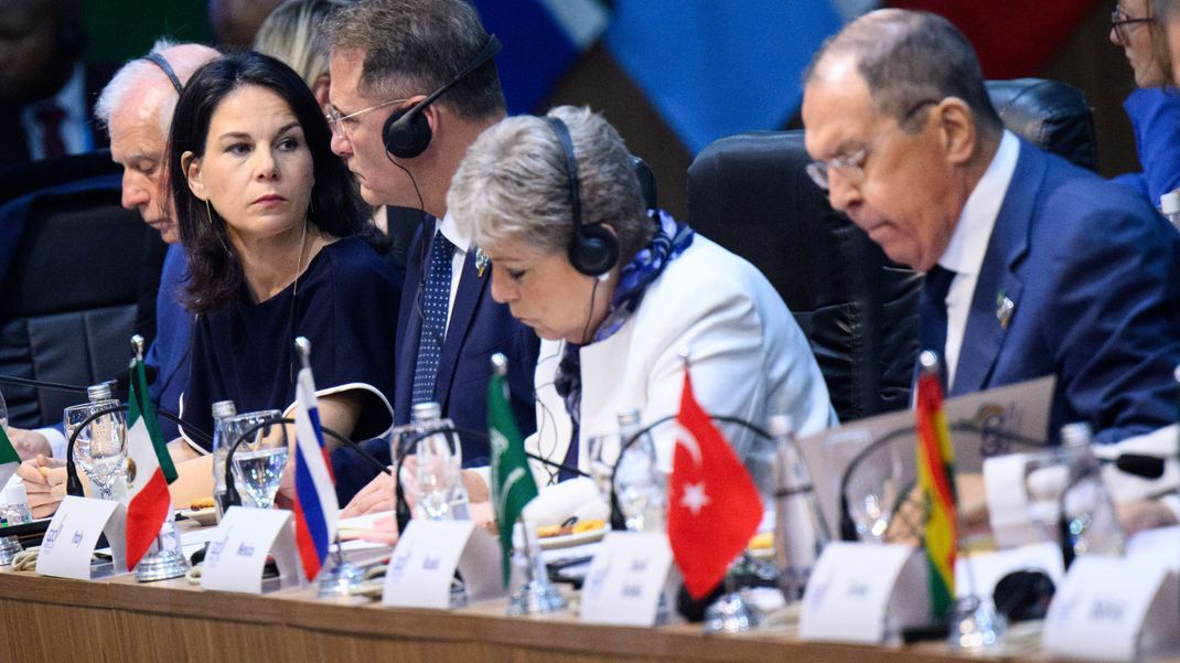 Außenministerin Annalena Baerbock sitzt nur drei Plätze neben Sergej Lawrow (r), Außenminister von Russland, zu Beginn der ersten Arbeitssitzung des G20-Außenministertreffens in Rio de Janeiro.