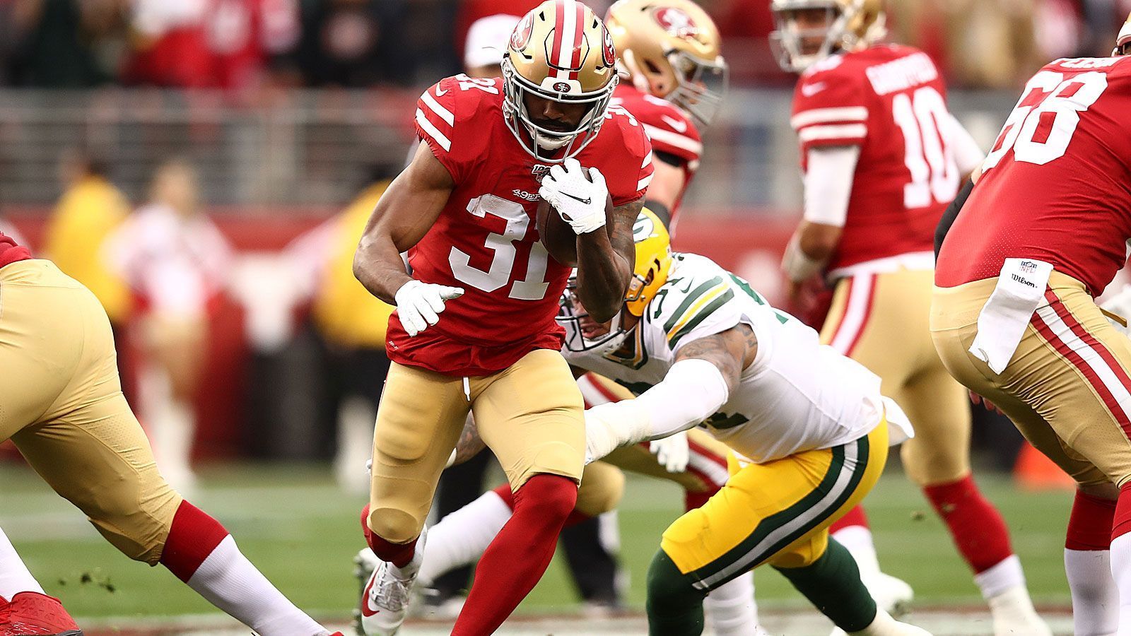 
                <strong>Gewinner: Raheem Mostert (San Francisco 49ers)</strong><br>
                29 mal bekam Raheem Mostert beim 37:20 seiner San Francisco 49ers über die Green Bay Packers den Ball. Dabei legte er sagenhafte 220 Yards zurück und erlief alle vier Touchdowns der Kalifornier. Es ist also nicht einmal stark übertrieben zu behaupten: Der Running Back, der sich die Snaps eigentlich mit Tevin Coleman und Matt Breida teilt, hat "The Pack" im Alleingang aus dem Weg geräumt. Eine andere Zahl demonstriert seine zentrale Rolle in der "Niners"-Offensive: Quarterback Jimmy Garoppolo warf den Ball lediglich achtmal - diesen Wert erreicht so mancher Playmaker in einem einzigen Drive.
              