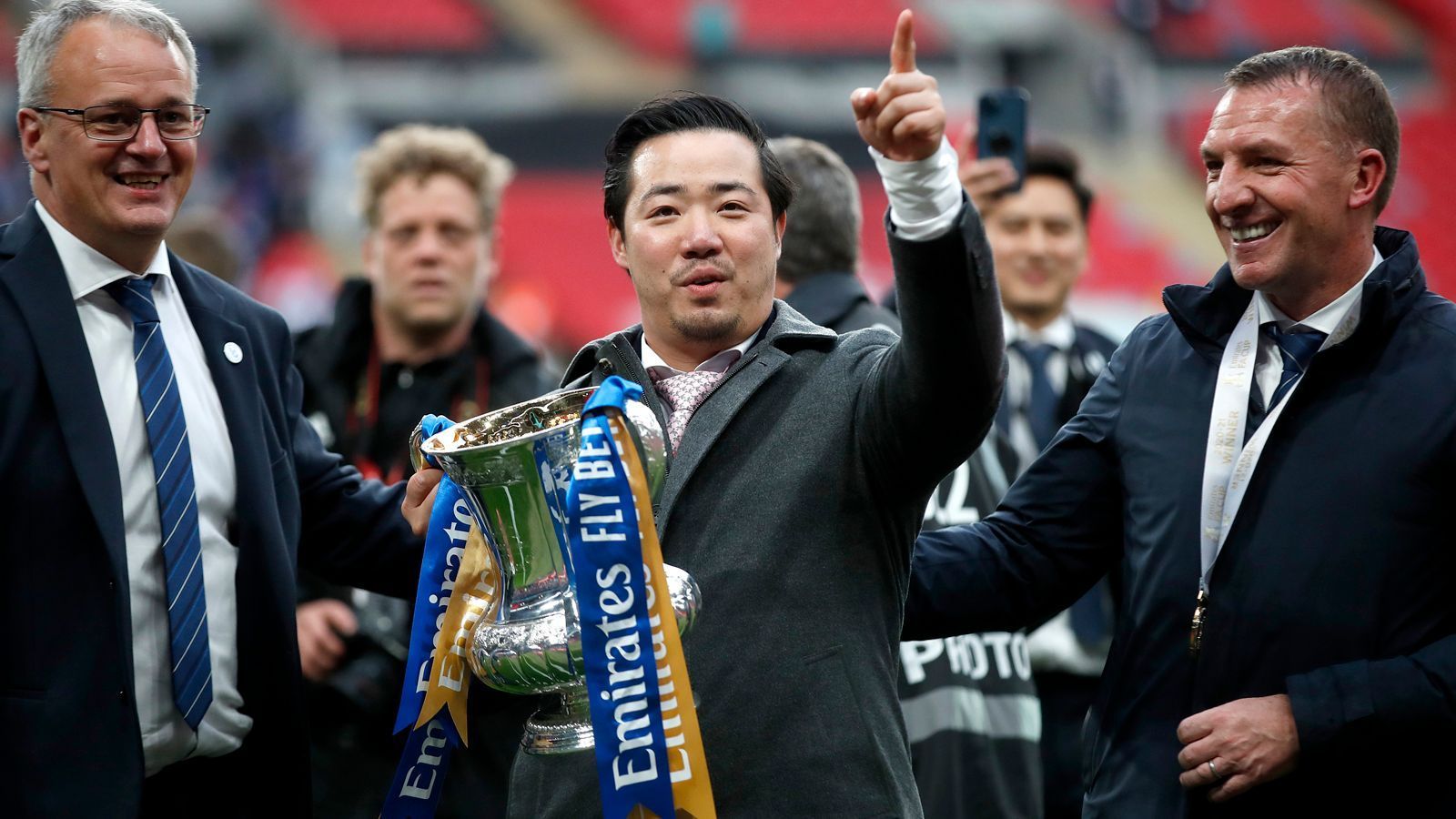 
                <strong>Emotionaler Moment für Besitzer Srivaddhanaprabha</strong><br>
                Mit auf dem Platz feierte Leicesters Besitzer Aiyawatt Srivaddhanaprabha den Sieg als Außenseiter im FA-Cup. Für den 35-jährigen Thailänder war es ein sehr emotionaler Moment. Zum einen ist es der erste Titel unter der Führung des Geschäftsmannes und zum anderen auch der erste Titel seit dem Tod seines Vaters Vichai im Oktober 2018. Damals hoben Vichai Srivaddhanaprabha und weitere Personen mit dem Hubschrauber des Klubbesitzers direkt aus Leicesters Stadion ab, stürzten anschließend unweit des King Power Stadiums ab. Neben dem damaligen Klubbesitzer starben alle weiteren Personen an Bord des Hubschraubers. Danach übernahm Sohn Aiyawatt Srivaddhanaprabha die Führung der "Foxes", mit denen Vater Vichai 2016 sensationell den Premier-League-Titel feiern konnte.
              