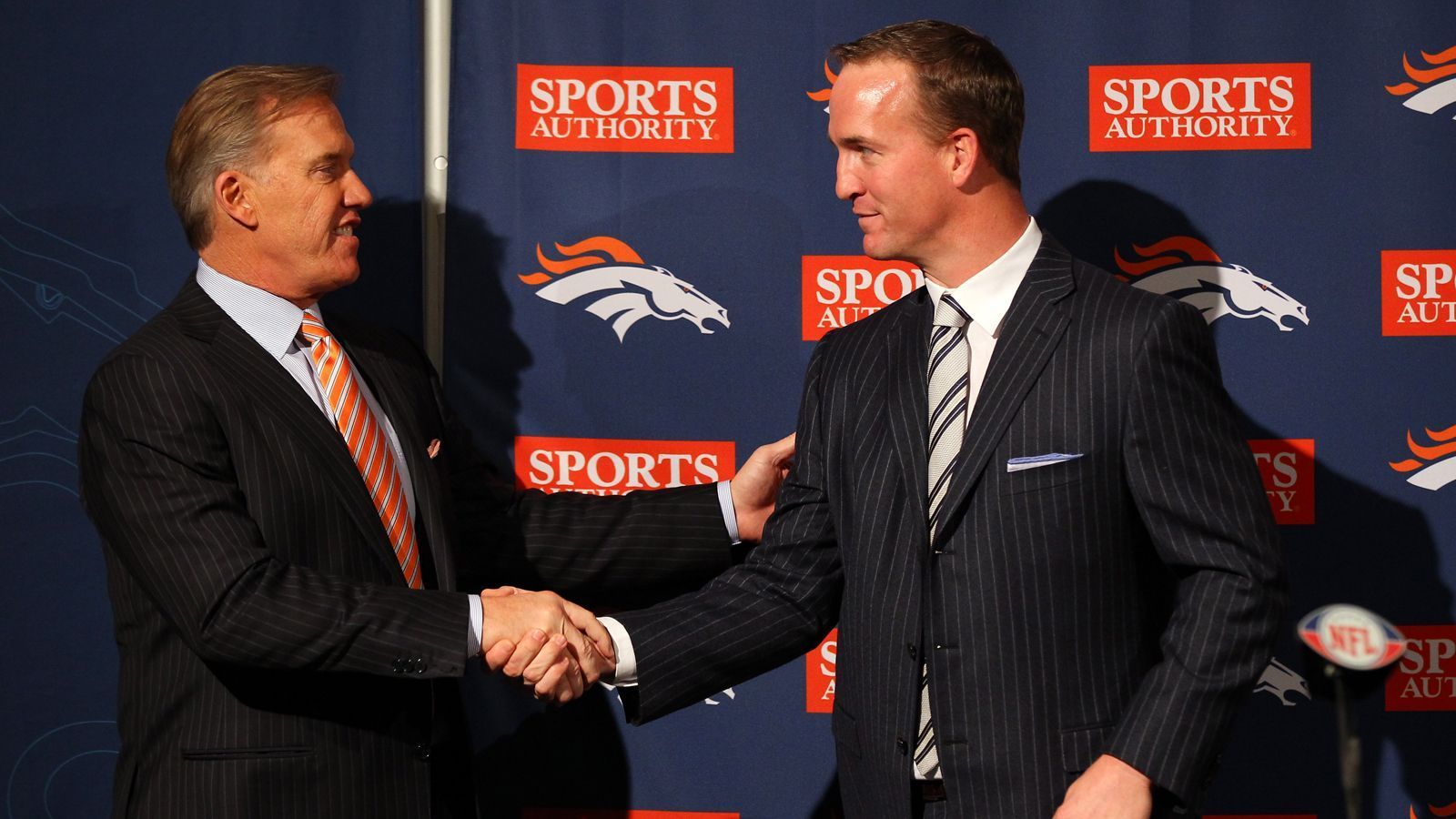 
                <strong>Peyton Manning</strong><br>
                Peyton Manning wurde nahezu als erste große Amtshandlung von John Elway verpflichtet. Der zukünftige Hall-of-Famer verabschiedete sich 2011 tränenreich von seinen Indianapolis Colts und wurde von Elway als Free Agent für fünf Jahre und 96 Millionen Dollar verpflichtet. Mit den Broncos holte sich Manning seinen fünften MVP-Titel (2013) und die zweite NFL-Meisterschaft (2016). In allen vier Jahren führte er sein Team in die Playoffs, 2013 erreichte er mit den Broncos erstmals den Super Bowl, verlor allerdings gegen die Seattle Seahawks. Nach dem großen Erfolg 2016 beendete er seine Karriere und hinterließ die bis heute anhaltende Lücke in Mile High. 
              