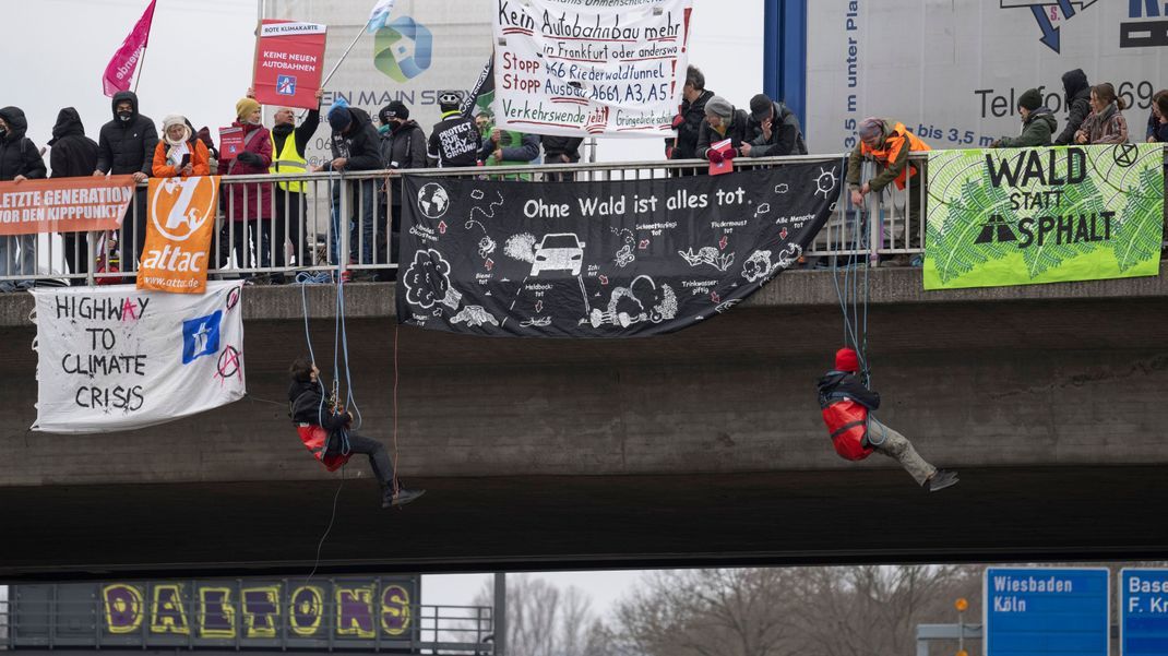 Aktivist:innen haben sich von einer Brücke über der Autobahn 648 in Frankfurt abgeseilt. Aufgerufen zu der Aktion hatte das Bündnis "Wald statt Asphalt".