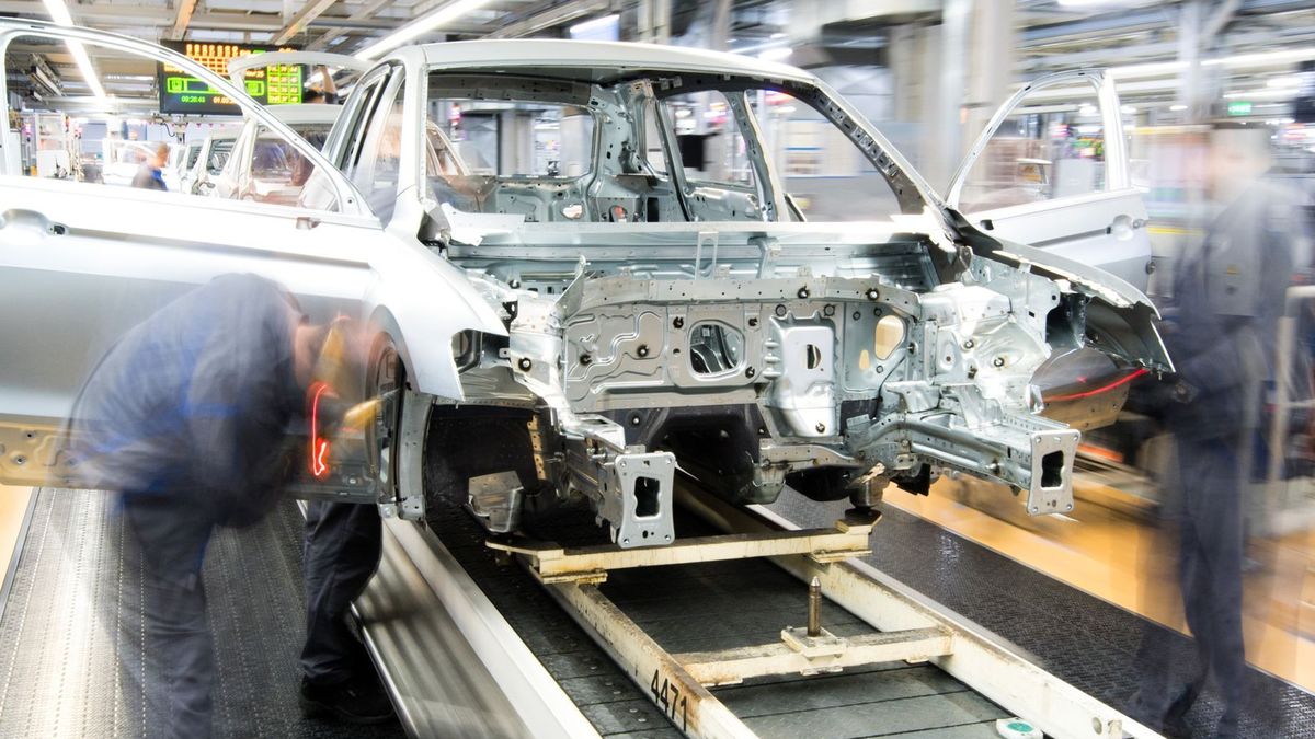 Mitarbeiter montieren Kotflügel an einem Auto