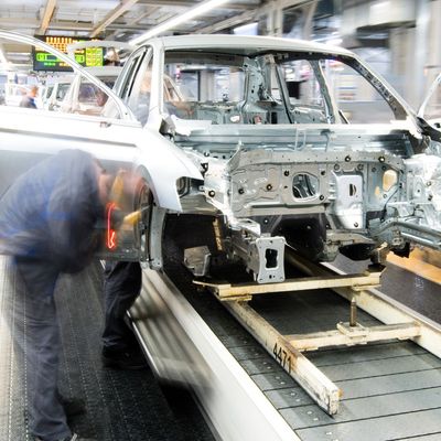 Mitarbeiter montieren Kotflügel an einem Auto