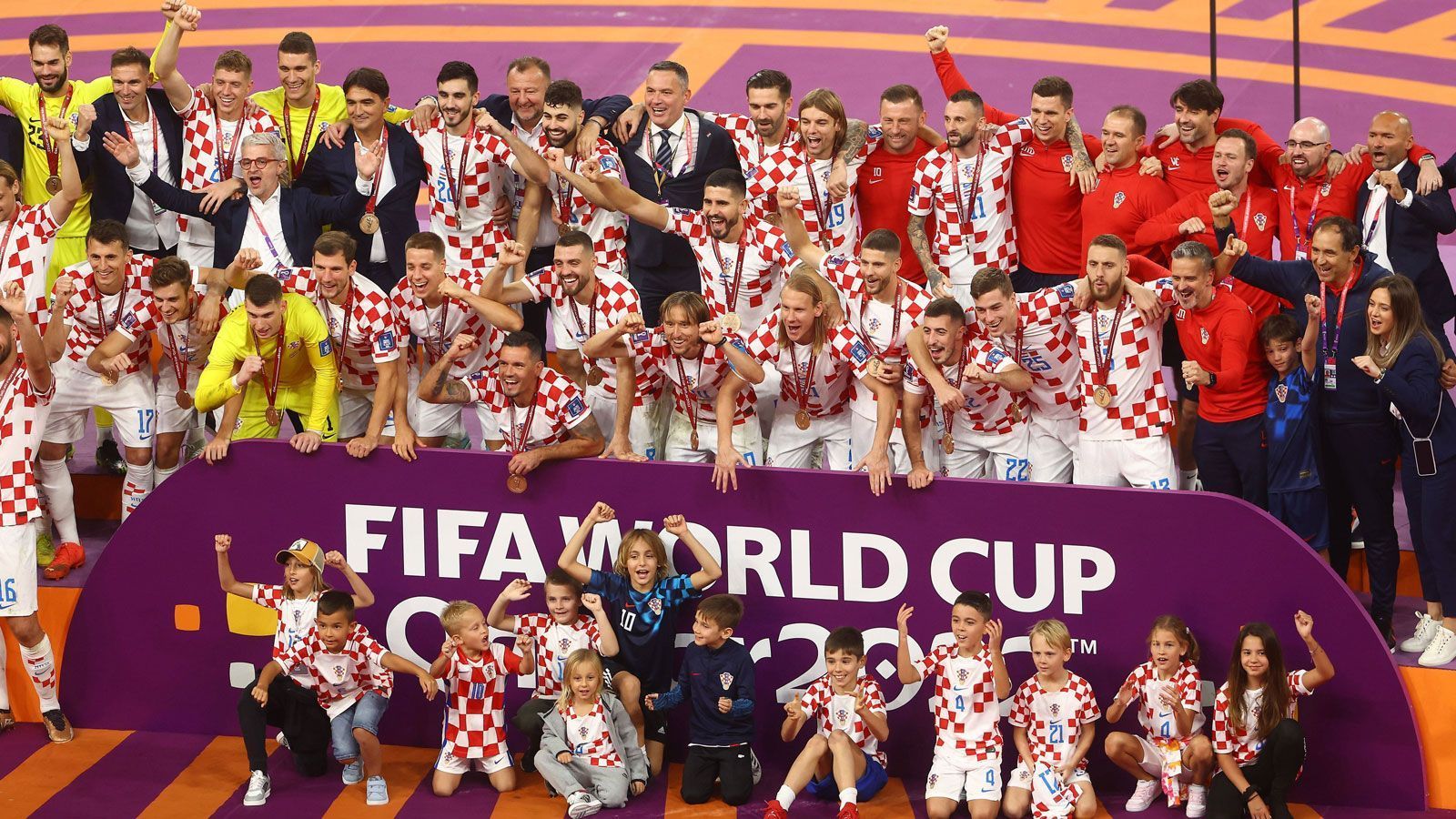 
                <strong>Siegerbild mit Kindern</strong><br>
                Auf der eilig aufgebauten Bühne werden die Bronzemedaillen an die stolzen Kroaten verteilt und dann wird zum Siegerfoto gebeten. Mit dabei auch der Nachwuchs vor der Bande. Wer weiß: Vielleicht mischt ja der eine oder die andere von den Kleinen irgendwann einmal auch auf der großen WM-Bühne mit.
              