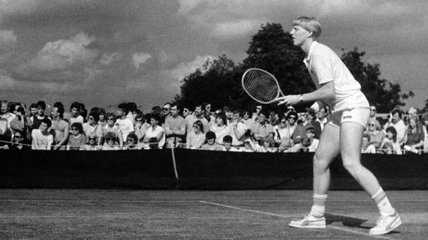 
                <strong>Der deutsche Außenseiter</strong><br>
                Als Boris Becker 1985 nach Wimbledon kommt, gilt der Leimener als Außenseiter. In seinen Erstrunden-Spielen muss der 17-Jährige vor stehenden Zuschauern auf Außenplätzen auflaufen, die Bilder dazu gibt es in schwarz-weiß. Becker siegt im ersten Spiel gegen den Amerikaner Hank Pfister mit 4:6, 6:3, 6:2, 6:4.
              