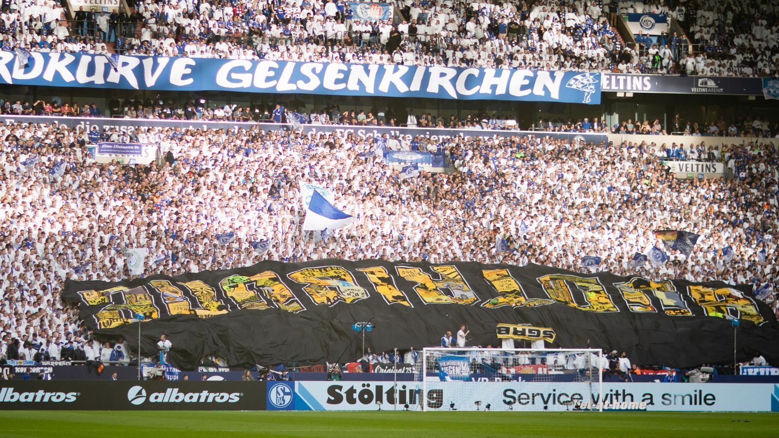 
                <strong>Bundesliga: Impressionen vom Revierderby 2019/20</strong><br>
                Auf der anderen Seite hatte auch die S04-Nordkurve ihren großen Auftritt, präsentierte ein offenbar von BVB-Fans ergattertes Banner.
              
