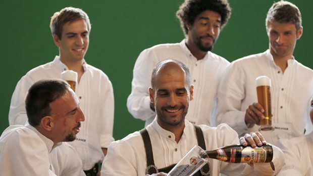 
                <strong>Götze, Guardiola und Co. beim Lederhosenshooting</strong><br>
                Echt zum Lachen: Der Franzose Franck Ribery weist den Spanier Pep Guardiola in die Geheimnisse des Weißbier-Einschenkens ein. Oberbayer Thomas Müller beäugt das Szenario mit kritischem Blick
              