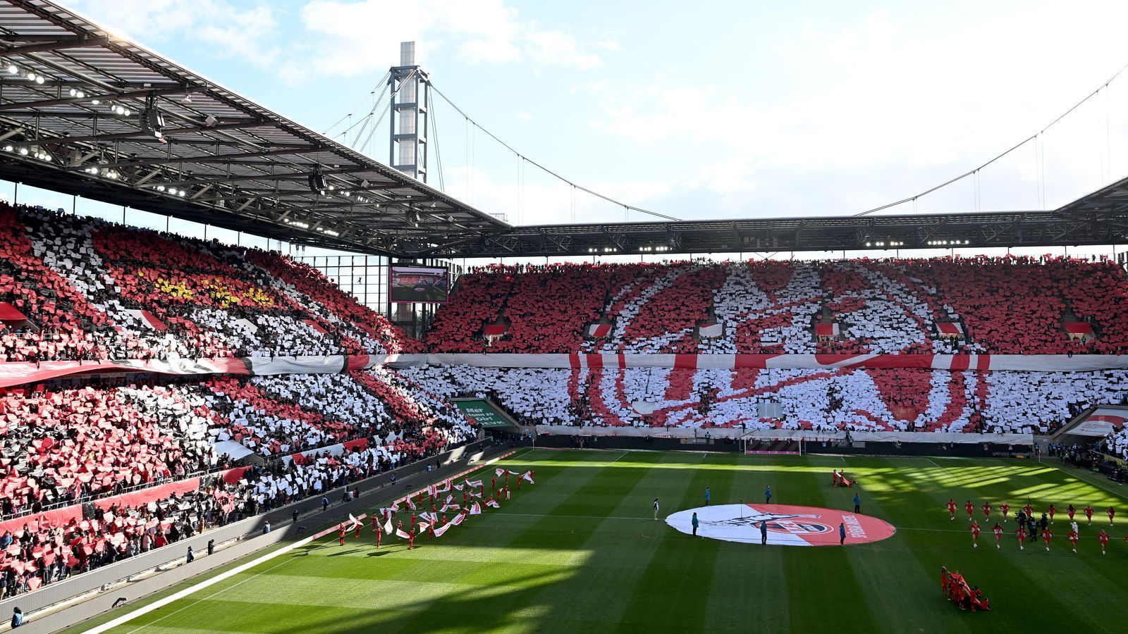 <strong>FC-Fans mit eindrucksvoller Choreo zum Vereinsjubiläum</strong><br>
                Der 1. FC Köln wurde am 13. Februar 2023 bereits 75 Jahre alt. Selbstverständlich nutzten die FC-Fans das Heimspiel gegen den VfL Wolfsburg, um dieses Jubiläum gebührend zu begehen. Mit einer eindrucksvollen Choreografie, die sich über das komplette Stadion erstreckte, feierten die Fans sich und ihren Verein. Dabei waren das Vereinslogo zu sehen, die Wappen der Vorgängervereine und Gründungsvater Franz Kremer.
