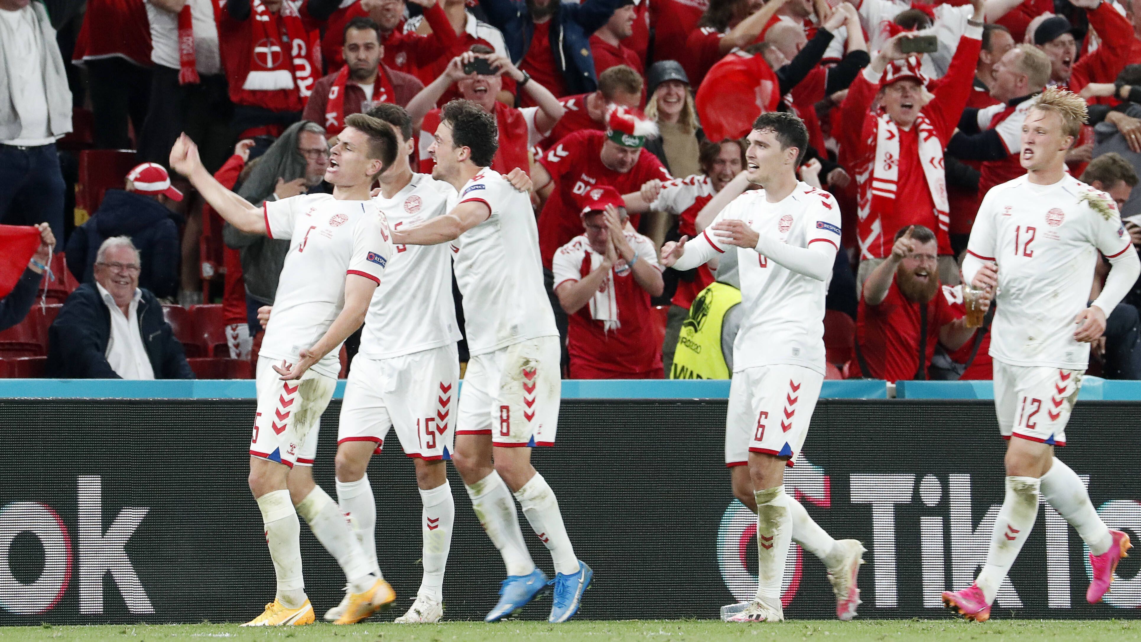 
                <strong>Dänemark macht das Unmögliche möglich - ein Spiel für die Geschichtsbücher </strong><br>
                Das dritte und gleichzeitig letzte Gruppenspiel der Staffel B zwischen Russland und Dänemark wird vielen Fußballfans noch länger im Gedächtnis bleiben: Nach dem dramatischen Zusammenbruch von Spielmacher Christian Eriksen und zwei bitteren Niederlagen fegten "Danish Dynamite" ihren Gegner mit 4:1 aus dem Stadion. Dank belgischer Schützenhilfe gelang dann auch noch der Sprung vom vierten auf den zweiten Tabellenplatz und damit ins Achtelfinale der EM. Nie zuvor war es einem Team gelungen, trotz zwei Auftaktniederlagen noch auf den vordersten beiden Plätze ihrer Gruppe zu landen. Ein würdiger Abschluss für ein denkwürdiges Spiel.
              