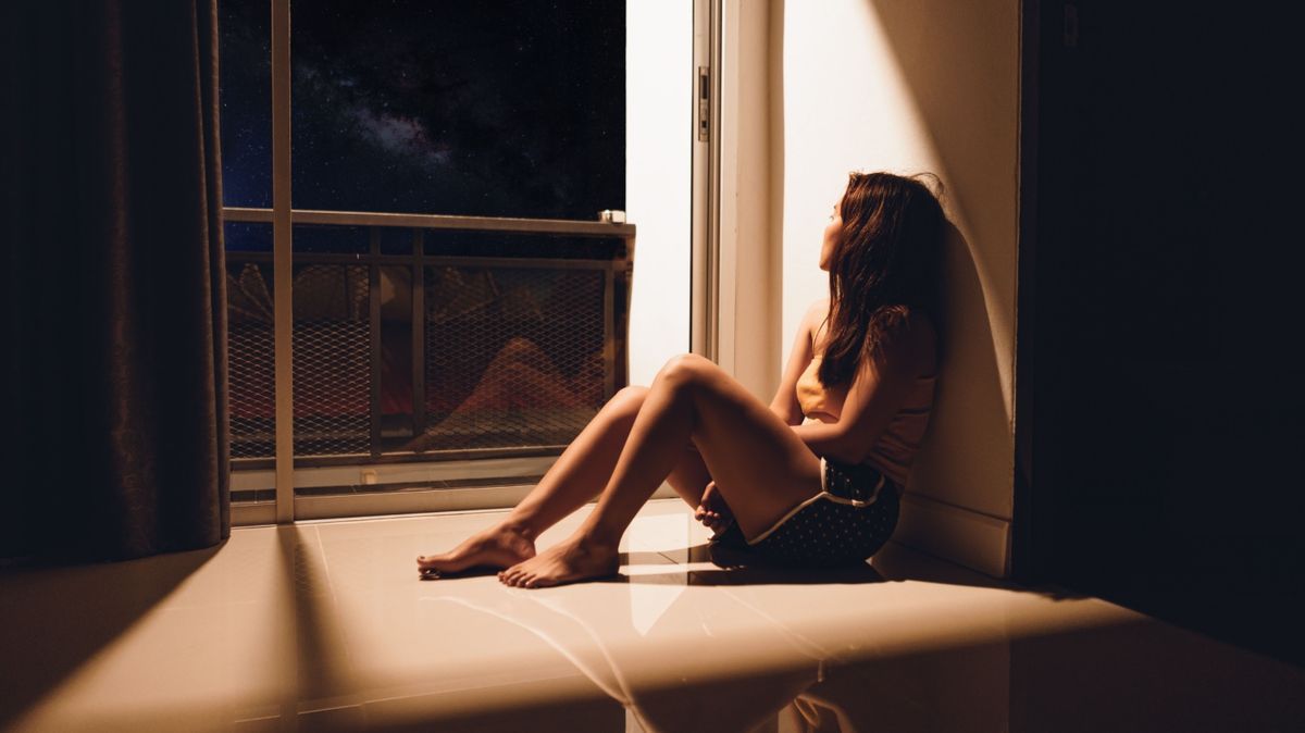 Einsame Frau auf Fensterbank