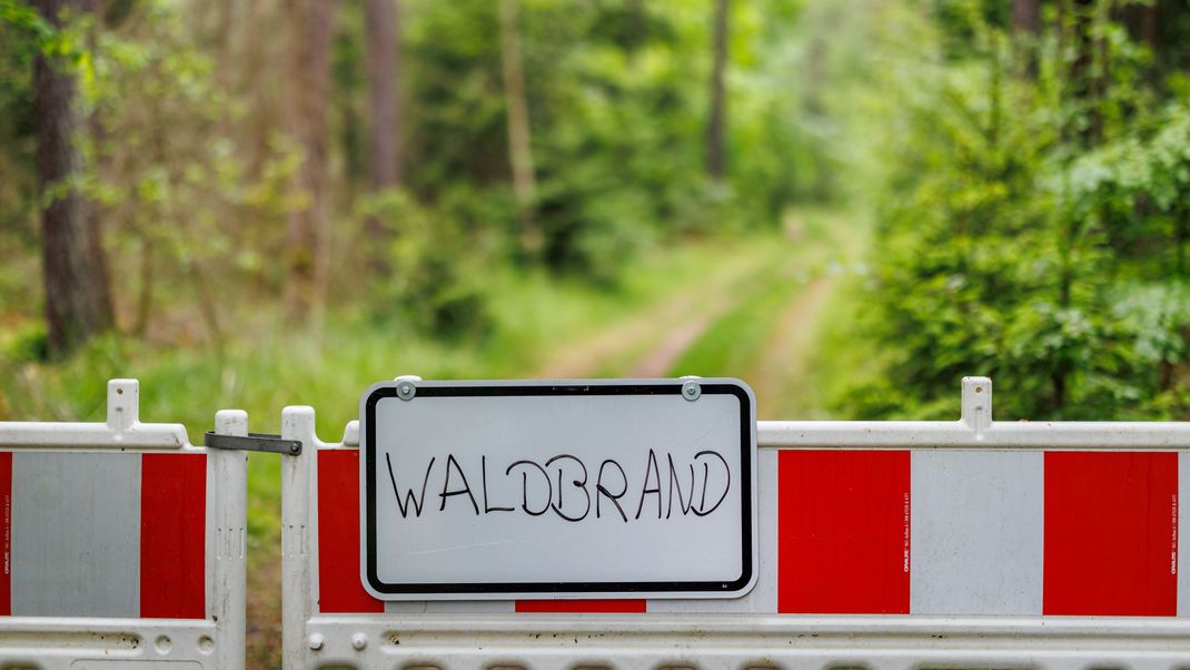 "Waldbrand" steht auf dem Schild an einem Absperrzaun im Tenneloher Forst bei Erlangen. 
