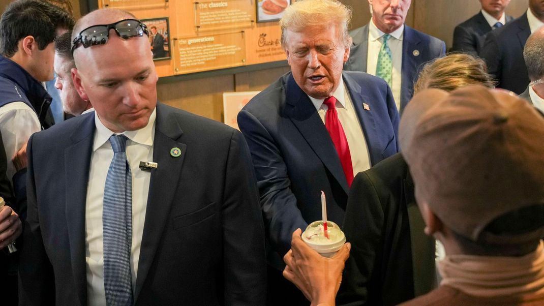 Der republikanische Präsidentschaftskandidat und ehemalige US-Präsident Donald Trump begrüßt Kund:innen in einem Chick-fil-A-Restaurant.
