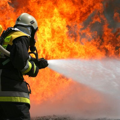 Ein Feuerwehrmann löscht ein Feuer.