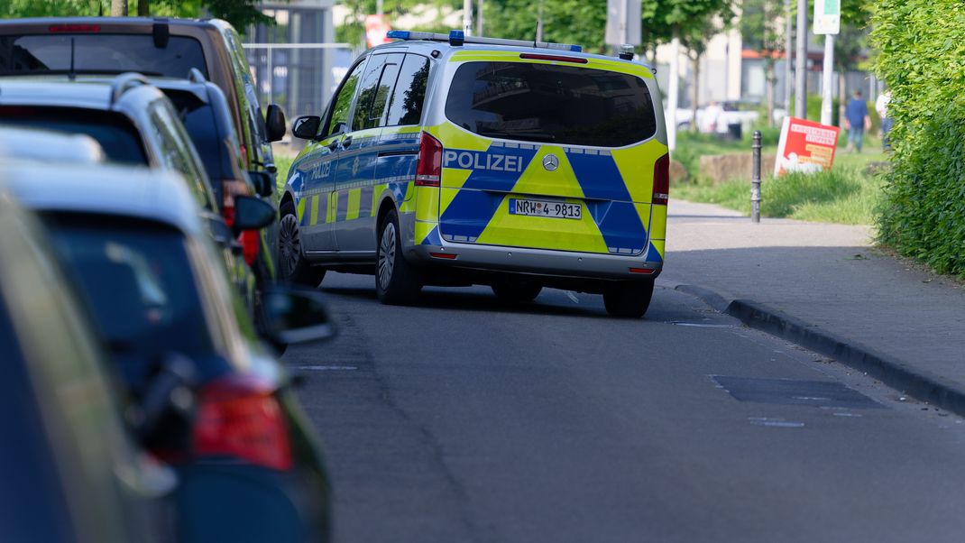 Ein Polizeiauto steht in einer Straße am Rand des Bürgerparks in Köln-Kalk. 