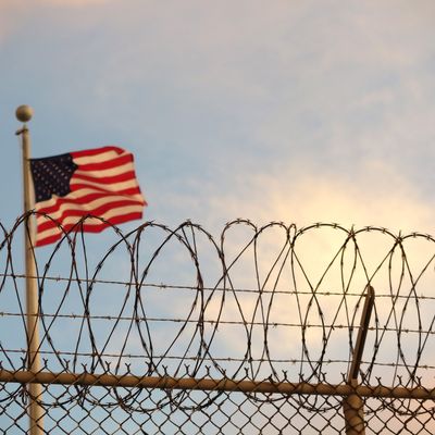 Archivaufnahme, 16. Oktober 2018, Kuba, Guantanamo Bay: Eine US-amerikanische Flagge weht hinter dem Stacheldrahtzaun im berüchtigten Gefangenenlager der US Navy in der Guantánamo-Bucht
