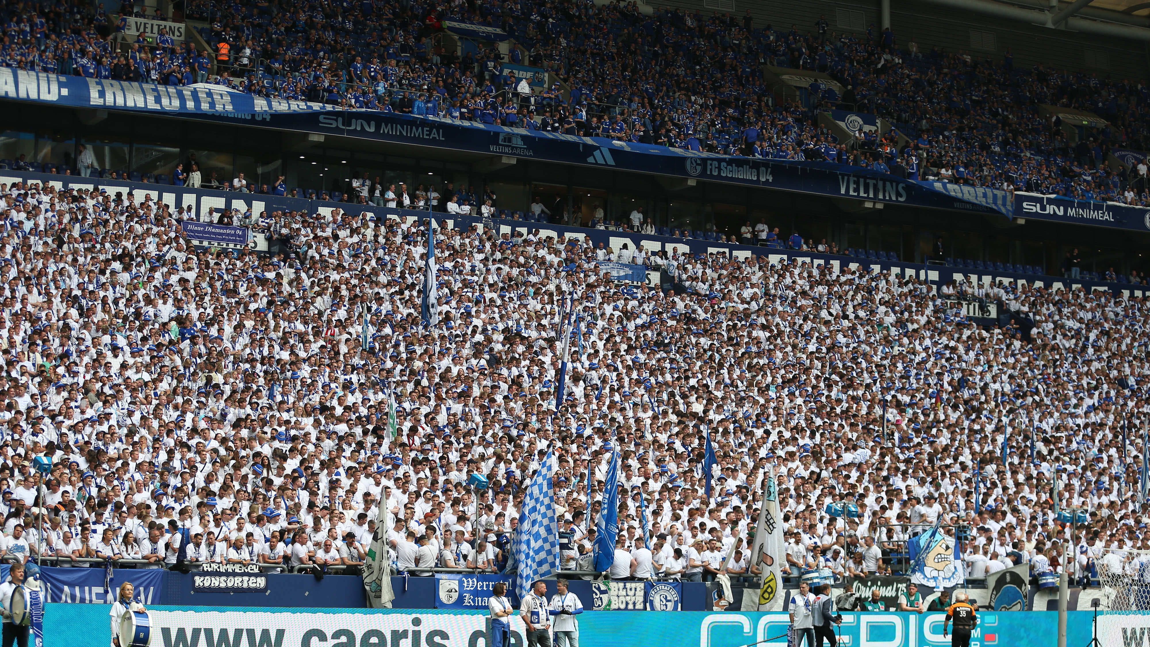 <strong>Schalke 04</strong><br>Im Jahr 2039 firmiert Schalke 04 unter dem Namen <strong>Revierwerk 04</strong>, powered by "H2-Kraft Ruhr AG". Die VELTINS-Arena heißt jetzt Glückauf-Powerdome, das Steigerlied wird von einem KI-Chor intoniert und Maskottchen Erwin wurde durch einen biertrinkenden Bergbau-Roboter ersetzt.