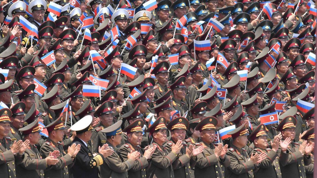 Nordkoreanische Soldaten schwenken die russische Flagge.