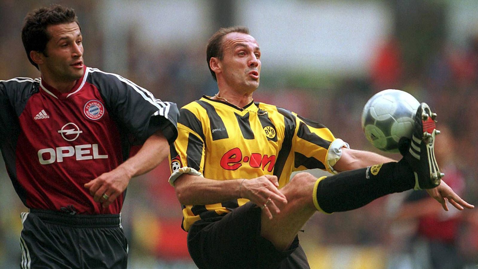 
                <strong>Jürgen Kohler, Weltmeister 1990</strong><br>
                Bundesliga-Spiele/-Tore: 191/14 für Dortmund, 55/6 für die Bayern. Der Innenverteidiger (im Bild re.) ist ein erfahrener Bundesliga-Profi und Nationalspieler, als er 1989 vom 1. FC Köln zu den Bayern geht. Zwei Jahre bleibt er dort, wird einmal Meister und wechselt dann zu Juventus. 1995 dann die Rückkehr nach Deutschland zum BVB. Kohler bleibt sieben Jahre und beendet nach zwei Meistertiteln und dem Gewinn der Champions Leage 2002 mit 36 Jahren seine Profikarriere.
              