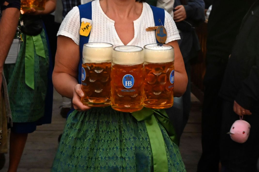 Mit vollen Bierkrügen durch die feiernde Menge auf dem Oktoberfest.