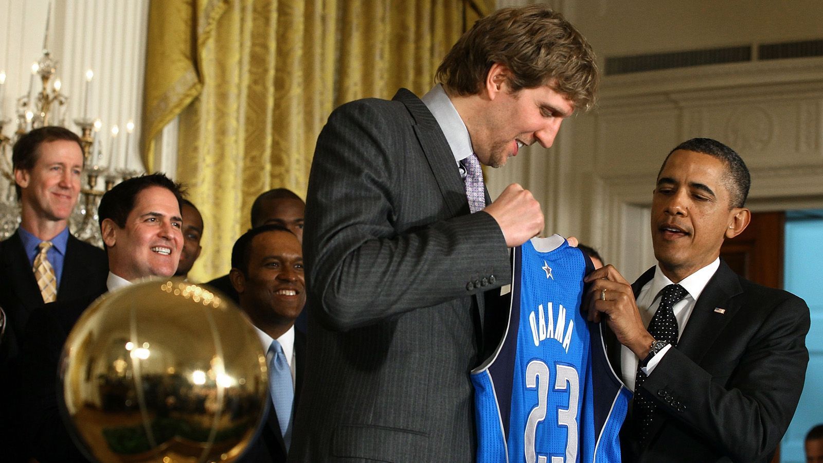 
                <strong>Dirk Nowitzki: Die Meilensteine seiner Karriere</strong><br>
                Nowitzki erfüllt sich seinen großen Traum, er erreicht 2011 den Höhepunkt seiner Karriere mit den Texanern: Nowitzki holt als erster Deutscher den NBA-Titel. In der Finalserie bezwingen die Mavs die favorisierten Miami Heat mit 4:2, Nowitzki wird zum wertvollsten Spieler der Finalserie gewählt. Zu den Gratulanten gehört auch der damalige US-Präsident Barack Obama.
              