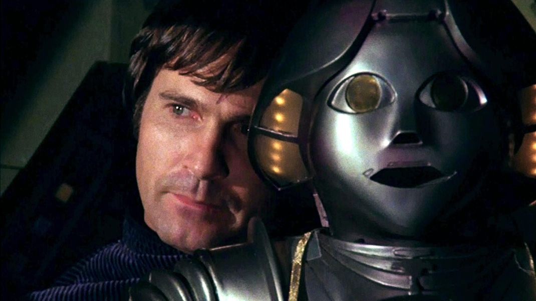 Gil Gerard in der Rolle als Astronaut William "Buck" Rogers und sein Begleiter Twiki, ein holografischer Roboter.