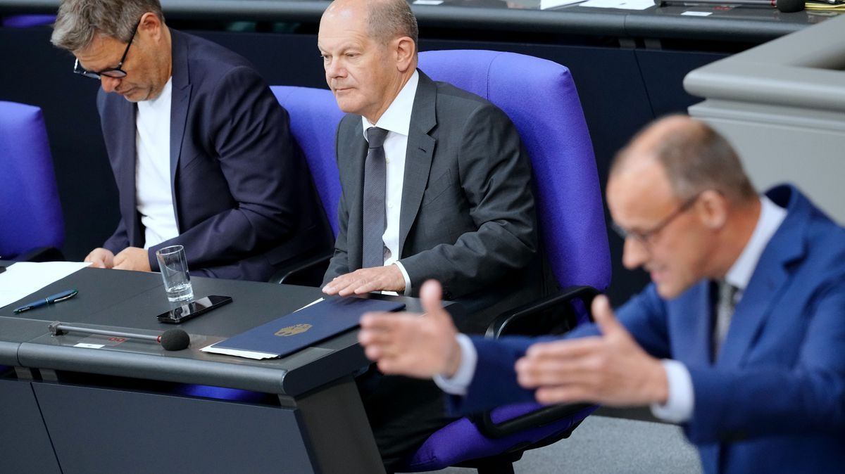 CDU-Chef Merz spricht im Bundestag, während Kanzler Scholz und Vize Habeck zuhören.