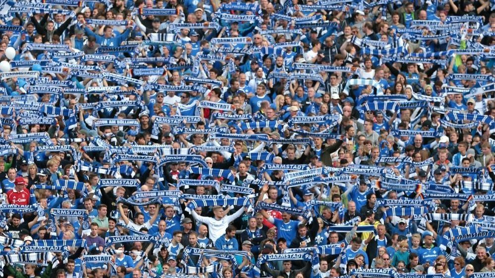 <strong>SV Darmstadt 98</strong><br>... kämpft im Stadion, durch Regen und Sonnenschein, für Darmstadt sind wir schon. Die Lilie, unser Wappen, so stark und klar, im Böllenfalltor, singen wir für Darmstadt, das ist wunderbar."