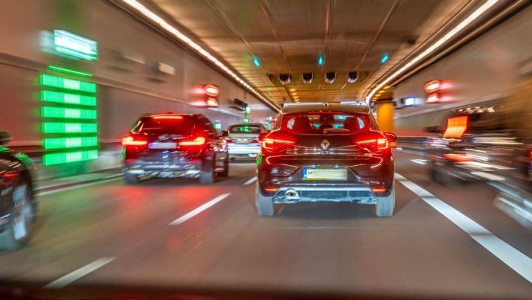 Autos mit aufleuchtenden Bremslichtern im dichten Verkehr in einem Tunnel.