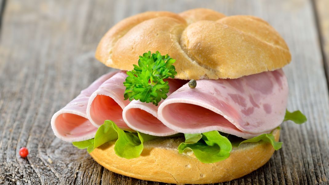 Garniertes Brötchen mit Schinkenwurst, Salatblatt und Petersilie - Roll with sliced ham sausage and lettuce leaf