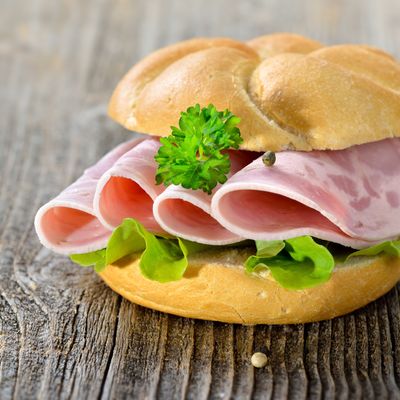 Garniertes Brötchen mit Schinkenwurst, Salatblatt und Petersilie - Roll with sliced ham sausage and lettuce leaf