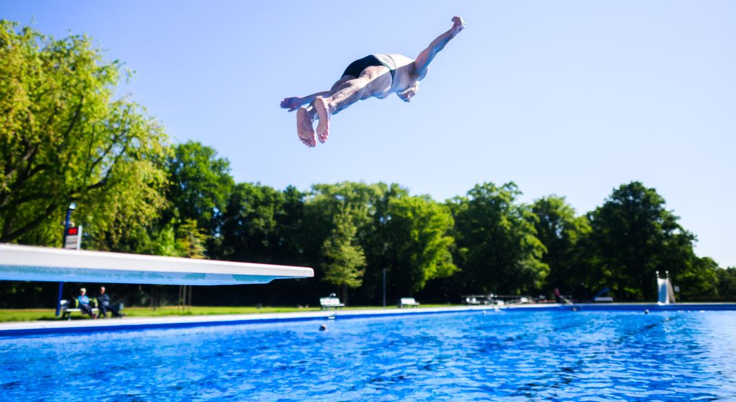 Ein Mann springt mit einem Kopfsprung vom Ein-Meter-Brett im Freibad Annabad. Deutschland könnte ein Extremsommer bevorstehen.