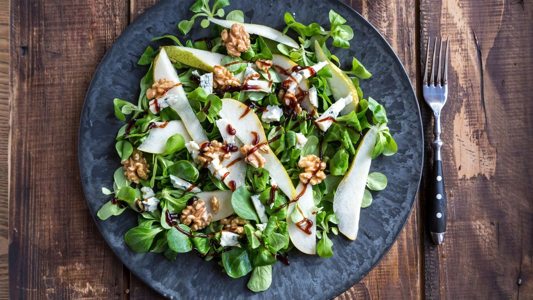 Ein erfrischender Herbstsalat, mit fruchtigen Birnen, kräftigem Käse und knackigen Nüssen.